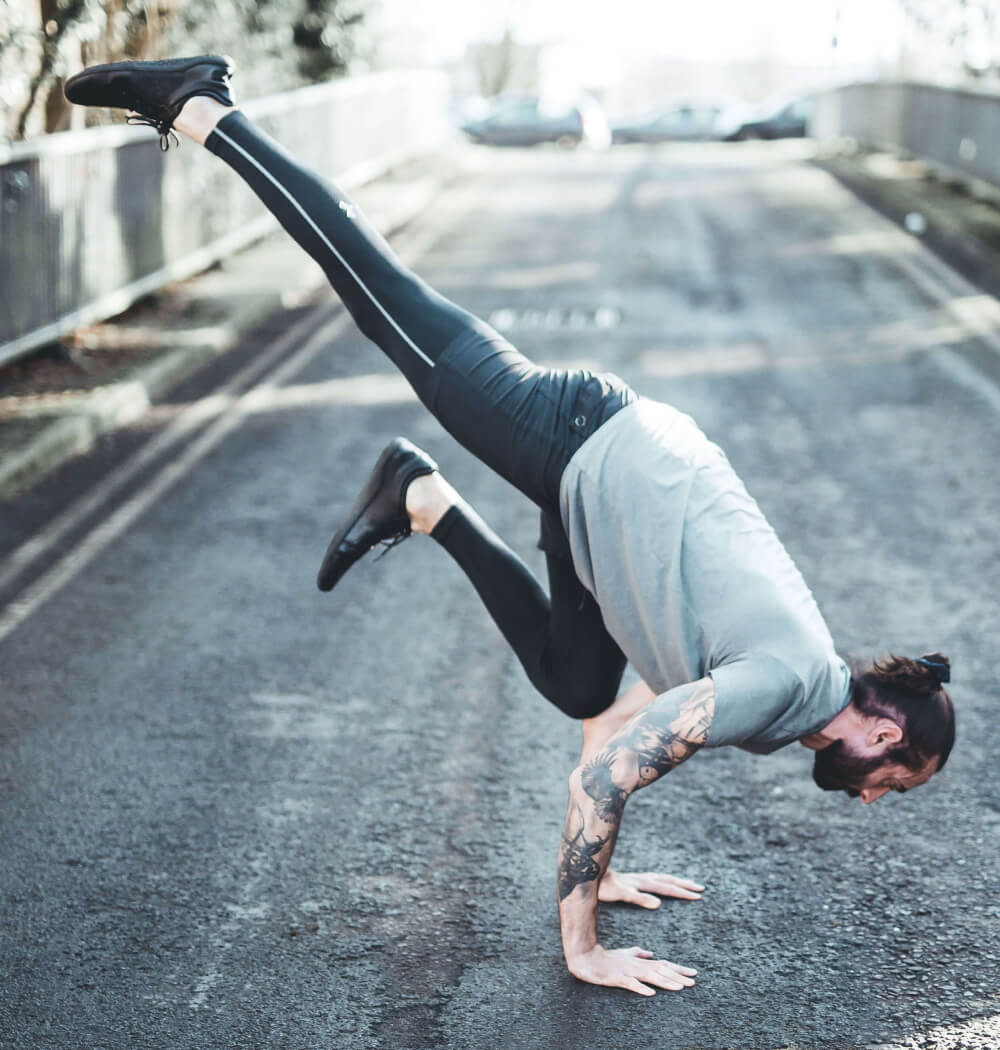 Yoga teacher Nate Thomas in one-legged crow pose